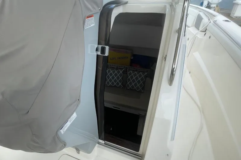 Slide: The Image of 2021 Pursuit S 328 Sport boat cabin entrance with storage baskets visible. - 39