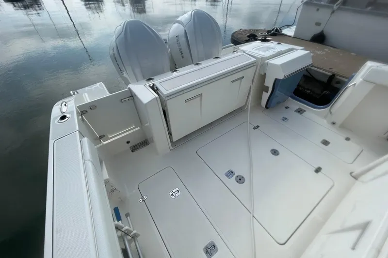 Slide: The Image of 2021 Pursuit S 328 Sport boat deck with storage compartments and twin engines. - 40
