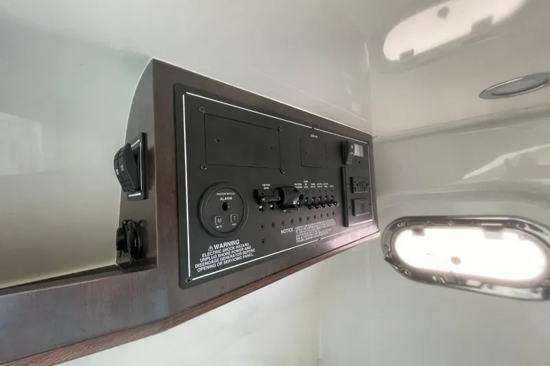 Slide: The Image of 2021 Pursuit S 328 Sport control panel with switches and warning labels. - 41