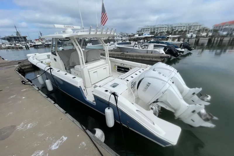 Slide: The Image of 2021 Pursuit S 328 Sport boat docked at marina with twin Yamaha engines. - 5