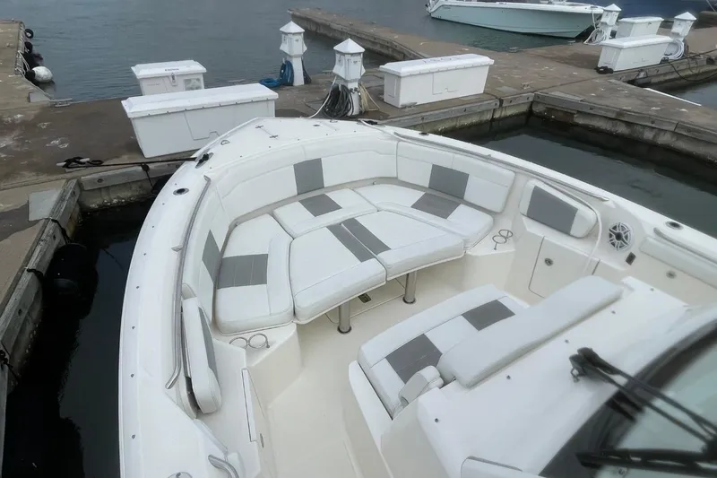 Slide: The Image of 2021 Pursuit S 328 Sport boat with spacious seating at a marina dock. - 9