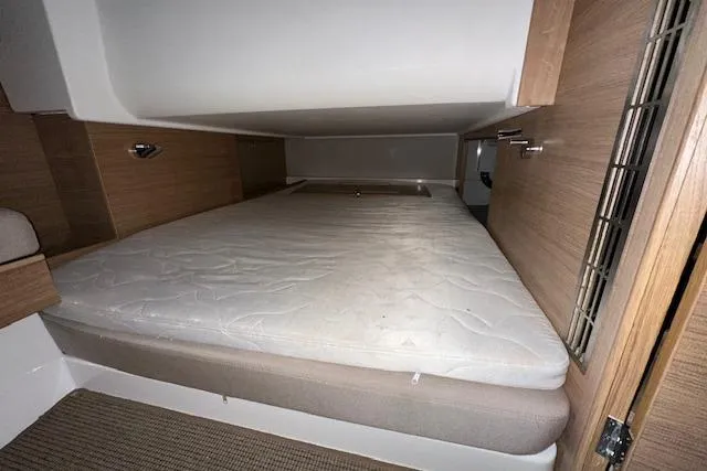 Slide: The Image of Cozy sleeping area in 2023 Nimbus C11 boat with wooden accents and comfortable mattress. - 10