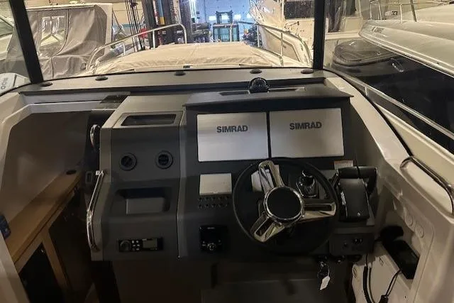Slide: The Image of Cockpit of 2023 Nimbus C11 boat with dual Simrad displays and steering wheel. - 12