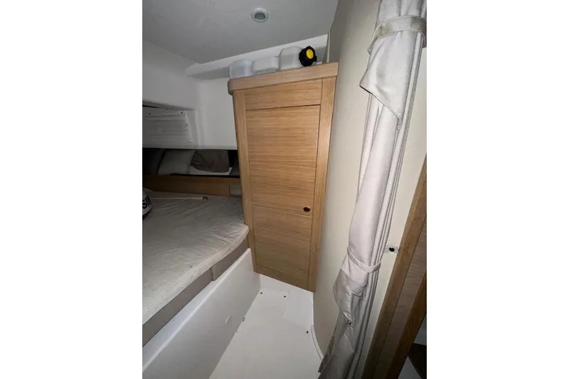 Slide: The Image of Interior of 2023 Nimbus C11 boat with wooden cabinetry and cozy sleeping area. - 16