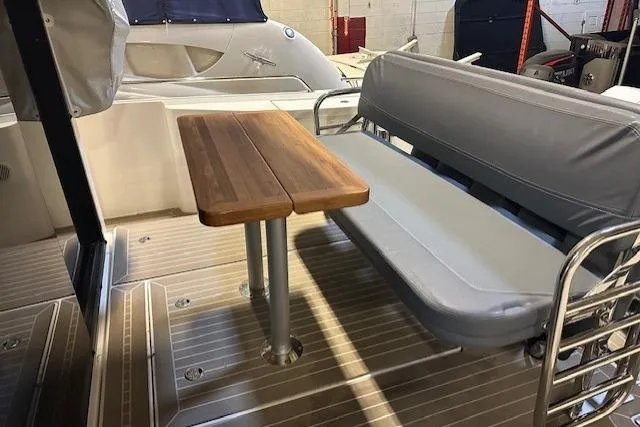 Slide: The Image of 2023 Nimbus C11 boat interior with wooden table and cushioned seating. - 21