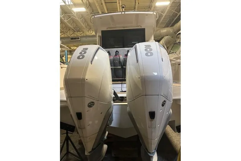 Slide: The Image of 2023 Nimbus C11 boat with dual 300 horsepower outboard engines in a warehouse setting. - 4