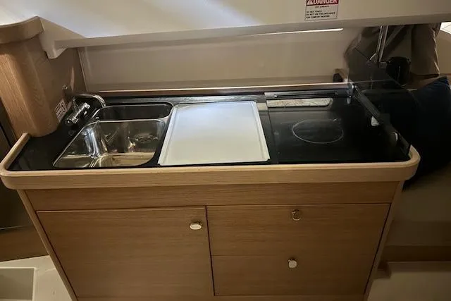 Slide: The Image of Compact kitchen area in a 2023 Nimbus C11 boat with sink and stove. - 5