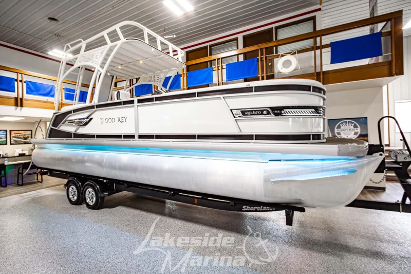 Slide: The Image of 2023 Godfrey AquaPatio 255 SDC pontoon boat on trailer in showroom. - 1