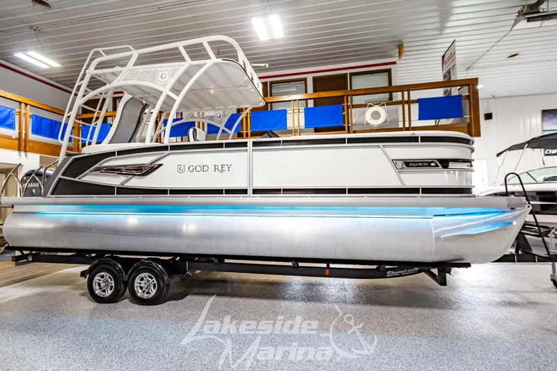 Slide: The Image of 2023 Godfrey AquaPatio 255 SDC pontoon boat on trailer in showroom. - 2
