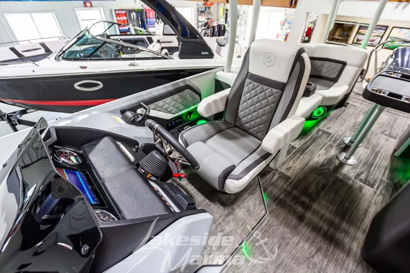 Slide: The Image of 2023 Godfrey AquaPatio 255 SDC boat interior with captain's chair and control console. - 25