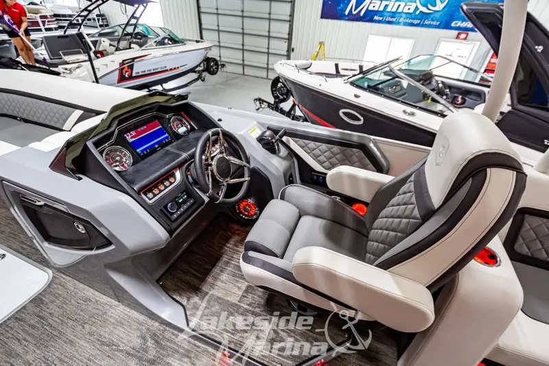 Slide: The Image of 2023 Godfrey AquaPatio 255 SDC boat interior with captain's chair and control panel. - 26