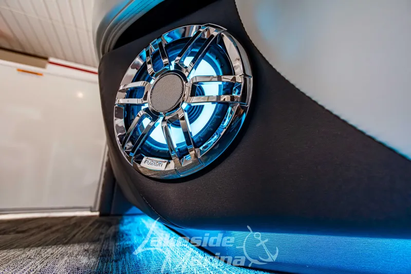 Slide: The Image of Close-up of 2023 Godfrey AquaPatio 255 SDC boat speaker with blue LED lighting. - 35
