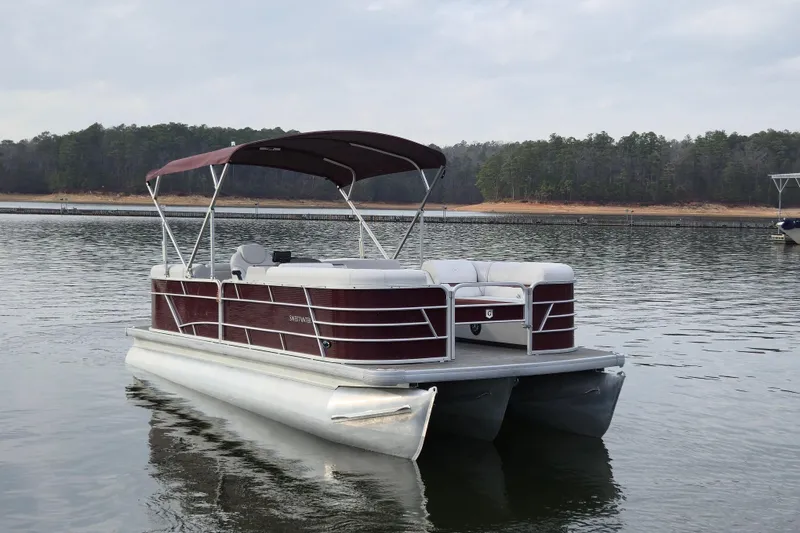 The Image of 2023 Godfrey Sweetwater 2286 C pontoon boat on a calm lake. - 1