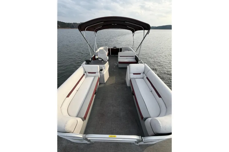 Slide: The Image of 2023 Godfrey Sweetwater 2286 C pontoon boat with spacious seating on a calm lake. - 11