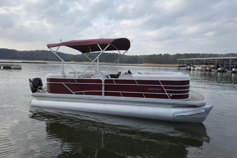 Slide: The Image of 2023 Godfrey Sweetwater 2286 C pontoon boat on a calm lake. - 2