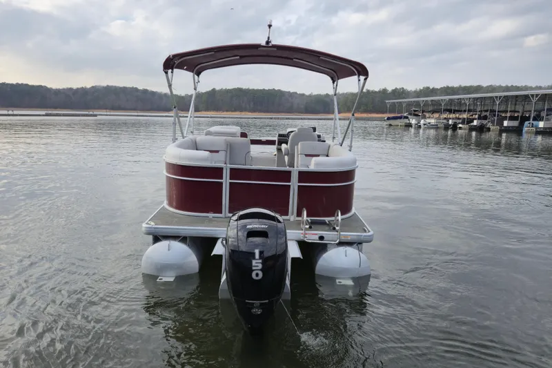 Slide: The Image of 2023 Godfrey Sweetwater 2286 C pontoon boat on calm lake waters. - 3