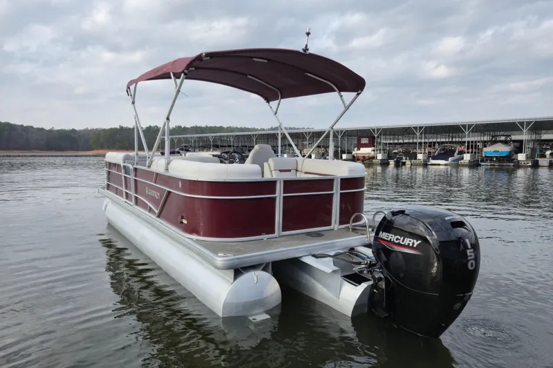 Slide: The Image of 2023 Godfrey Sweetwater 2286 C pontoon boat with Mercury engine on a calm lake. - 4