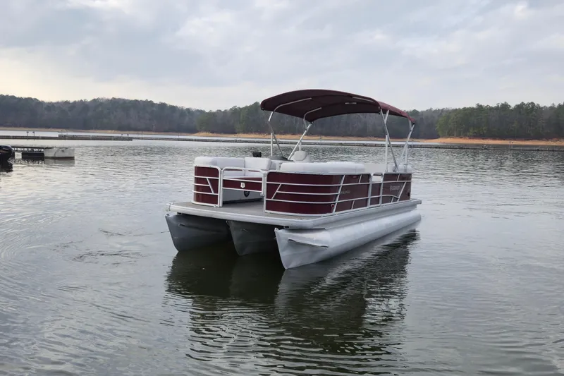 Slide: The Image of 2023 Godfrey Sweetwater 2286 C pontoon boat on a calm lake. - 6