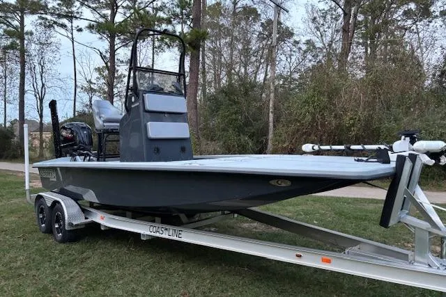 Slide: The Image of 2025 Freedom Boats 23' Warrior on trailer, parked outdoors near trees. - 2