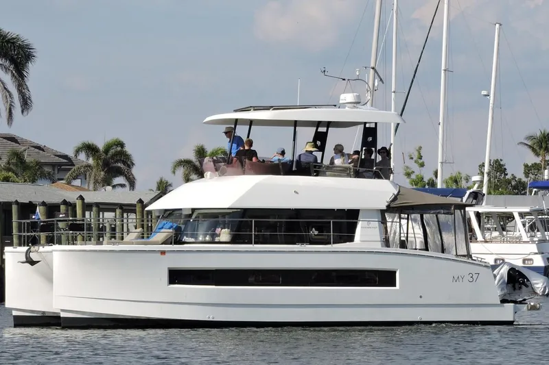 The Image of 2020 Fountaine Pajot MY 37 yacht cruising near a marina with palm trees. - 0