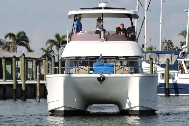 Slide: The Image of 2020 Fountaine Pajot MY 37 yacht docked with people onboard, surrounded by palm trees. - 1