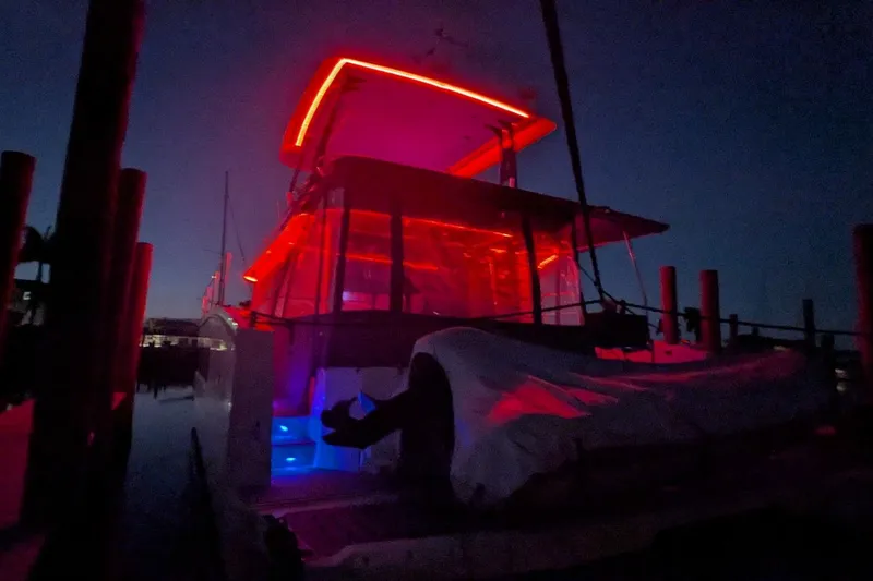 Slide: The Image of 2020 Fountaine Pajot MY 37 yacht illuminated with vibrant red and blue lights at night. - 5