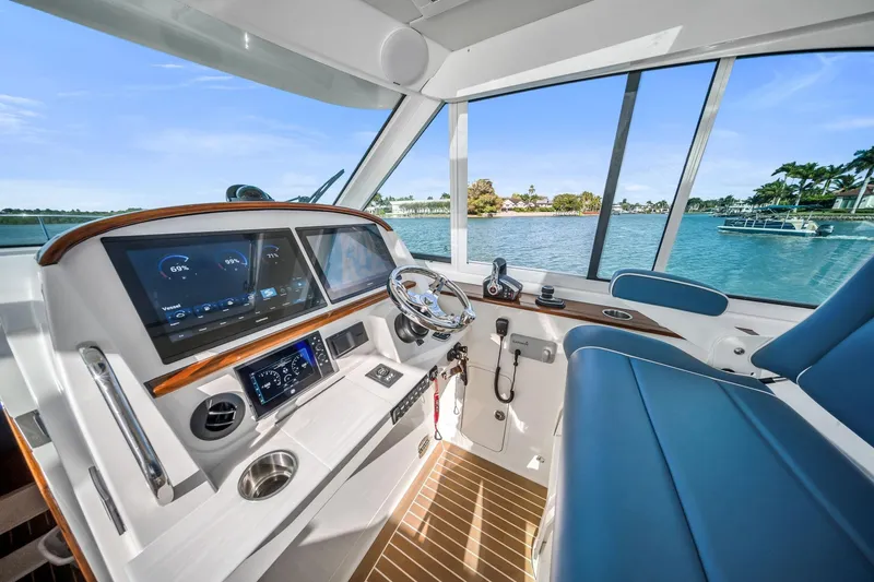 Slide: The Image of Interior view of 2025 Hinckley Sport Boat 40 X cockpit with modern controls and scenic water view. - 6