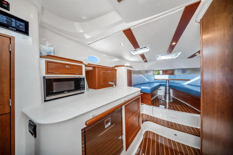 Slide: The Image of Luxurious interior of 2025 Hinckley Sport Boat 40 X with modern kitchen and seating area. - 8