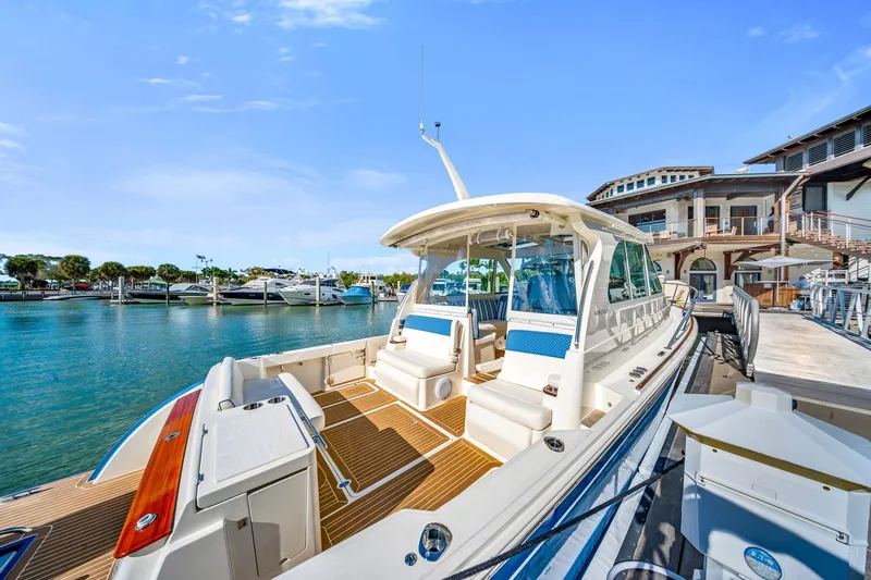 Slide: The Image of 2025 Hinckley Sport Boat 40 X docked at a marina under clear blue skies. - 2