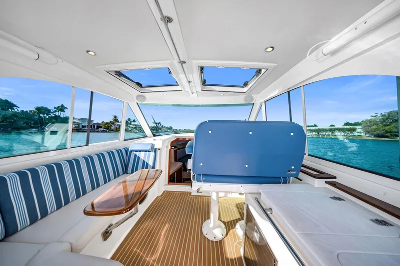 Slide: The Image of Interior of 2025 Hinckley Sport Boat 40 X with blue seating and scenic water view. - 5