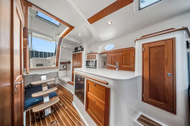 Slide: The Image of Interior of 2025 Hinckley Sport Boat 40 X, featuring elegant wood finishes and modern amenities. - 7