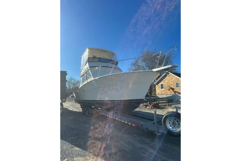 The Image of 1988 Viking 35 Convertible boat on trailer under clear blue sky. - 0