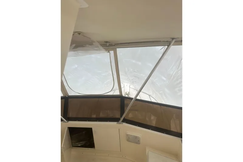Slide: The Image of 1988 Viking 35 Convertible boat interior with clear windows and beige panels. - 11