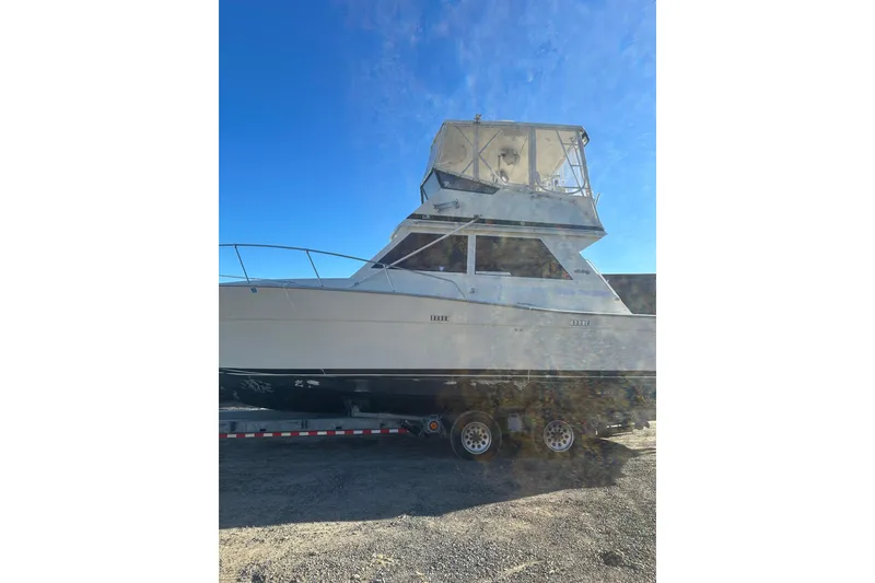 Slide: The Image of 1988 Viking 35 Convertible boat on trailer under clear blue sky. - 2