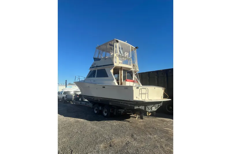 Slide: The Image of 1988 Viking 35 Convertible boat on trailer under clear blue sky. - 3