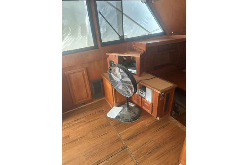 Slide: The Image of 1988 Viking 35 Convertible interior with wooden cabinetry and a floor fan. - 35