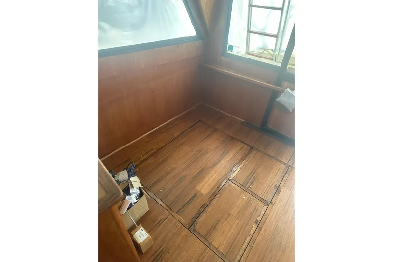 Slide: The Image of Interior of 1988 Viking 35 Convertible boat with wooden flooring and window view. - 36