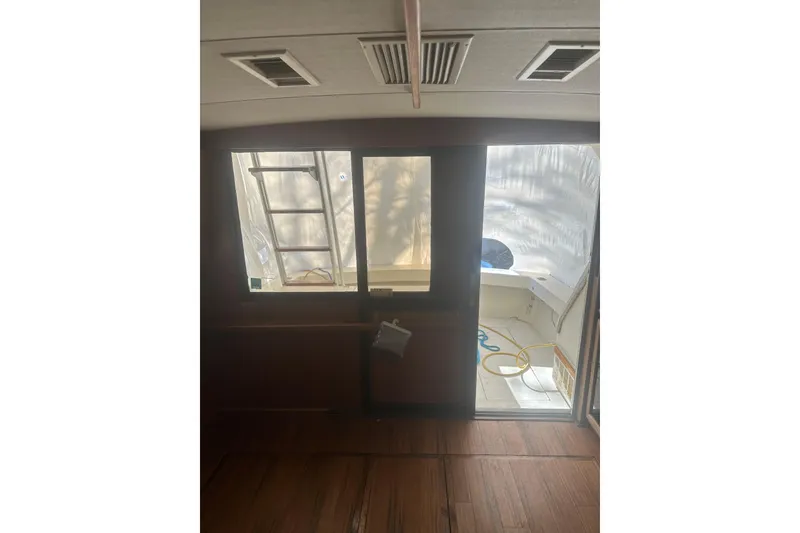 Slide: The Image of Interior view of 1988 Viking 35 Convertible boat with wooden flooring and outdoor access. - 37