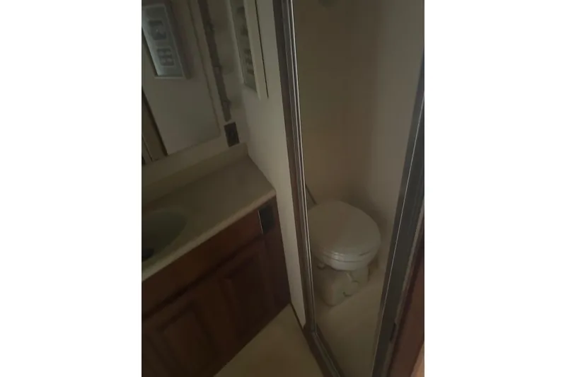 Slide: The Image of Bathroom interior of 1988 Viking 35 Convertible yacht, featuring a compact toilet and sink. - 39