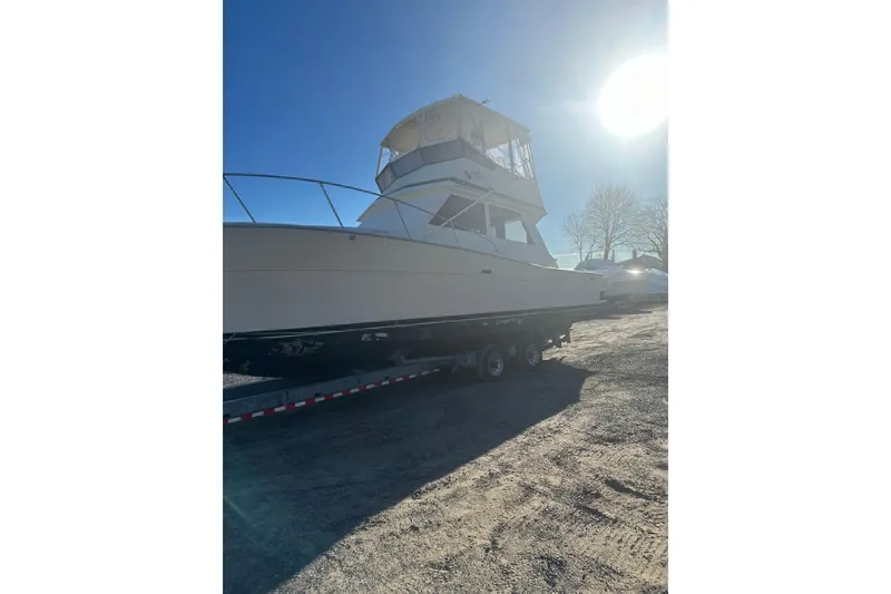 Slide: The Image of 1988 Viking 35 Convertible boat on trailer under clear blue sky. - 6