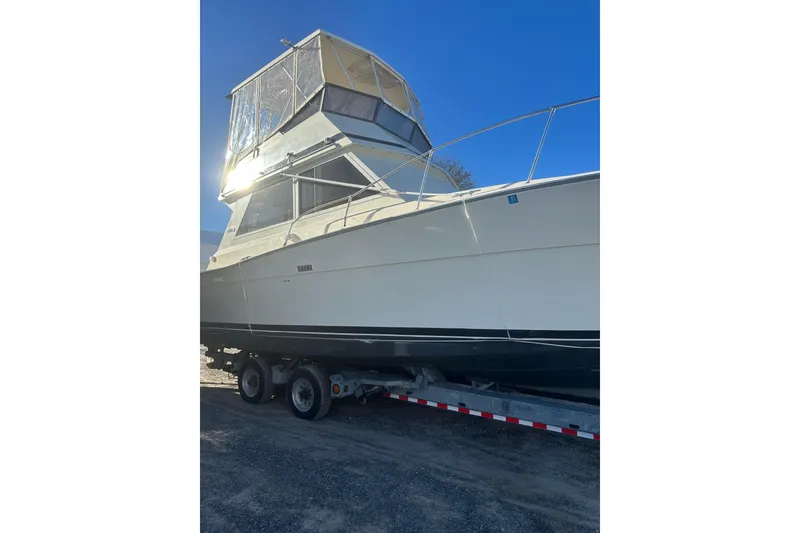 Slide: The Image of 1988 Viking 35 Convertible boat on trailer under clear blue sky. - 8