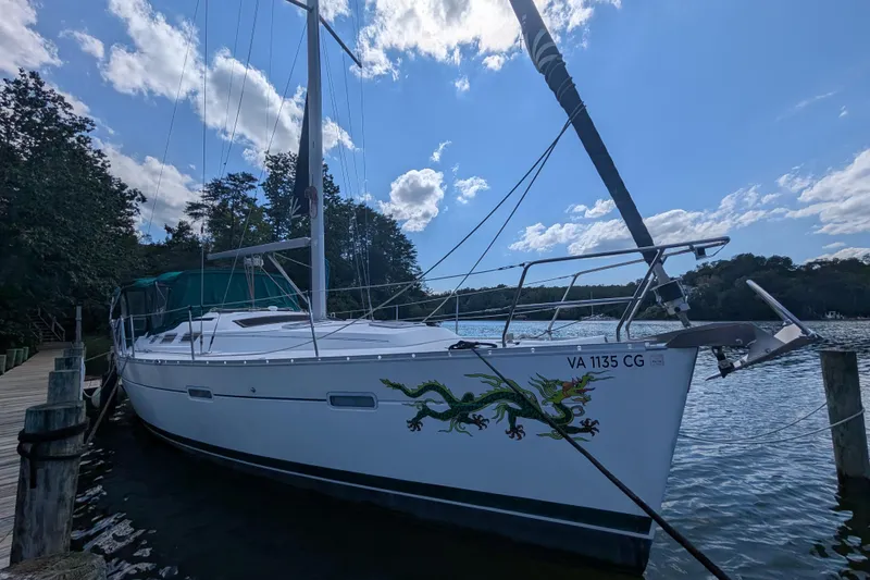 The Image of 2006 Beneteau Oceanis Clipper 373 sailboat docked, featuring dragon artwork on the hull. - 0