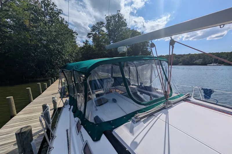 Slide: The Image of 2006 Beneteau Oceanis Clipper 373 docked by a serene lake under a sunny sky. - 10
