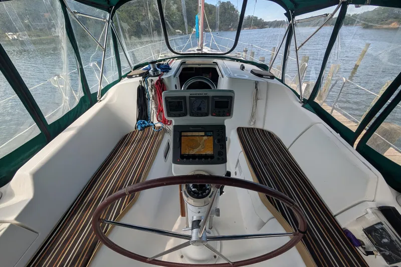 Slide: The Image of Cockpit of 2006 Beneteau Oceanis Clipper 373 sailboat with navigation equipment and wooden seating. - 13