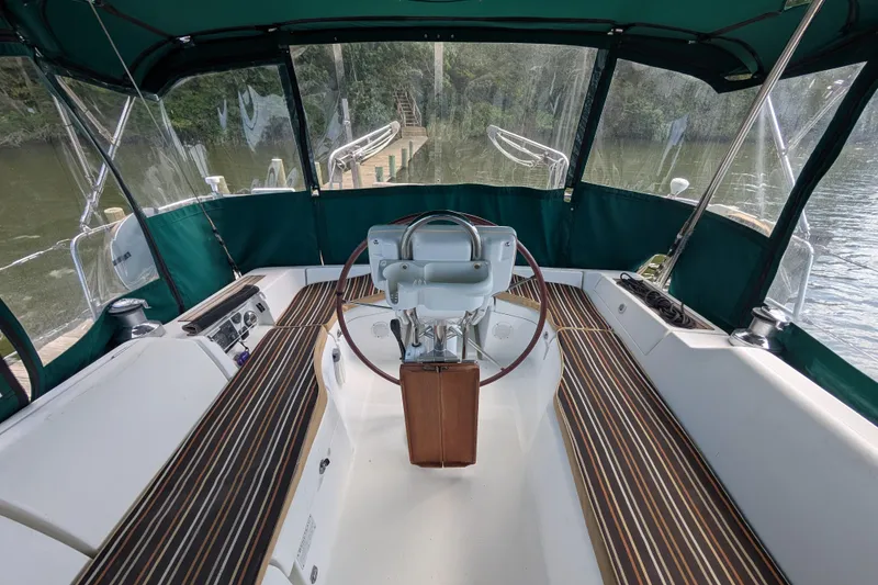 Slide: The Image of Cockpit of 2006 Beneteau Oceanis Clipper 373 sailboat with green canopy and wooden accents. - 14