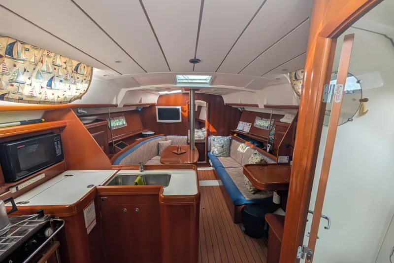 Slide: The Image of Interior of 2006 Beneteau Oceanis Clipper 373 sailboat with cozy seating and kitchen area. - 17