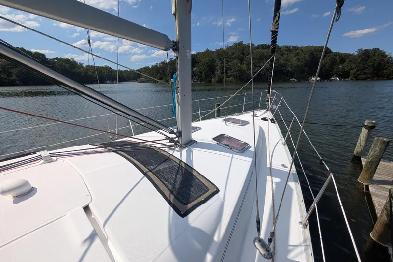 Slide: The Image of 2006 Beneteau Oceanis Clipper 373 sailboat docked on a serene lake. - 2