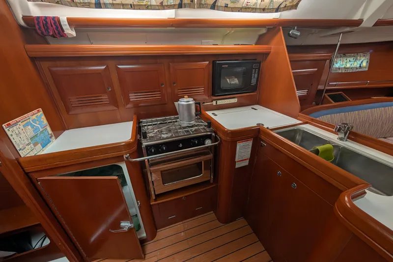 Slide: The Image of 2006 Beneteau Oceanis Clipper 373 yacht kitchen with stove, microwave, and sink. - 21