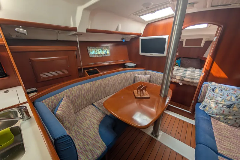 Slide: The Image of 2006 Beneteau Oceanis Clipper 373 interior with cozy seating and wooden finishes. - 22