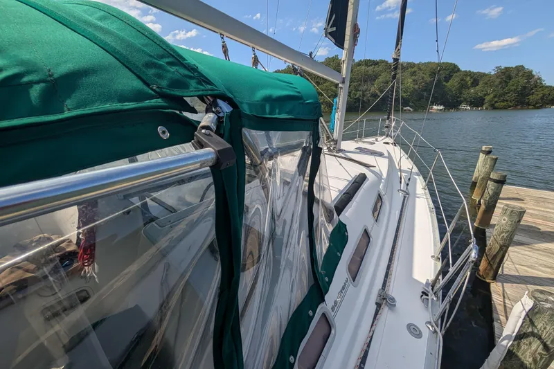 Slide: The Image of 2006 Beneteau Oceanis Clipper 373 sailboat docked, featuring green canopy and clear panels. - 3